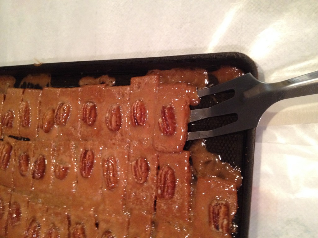 Using spatula to remove cookies from cookie sheet to place on wax paper for cooling.