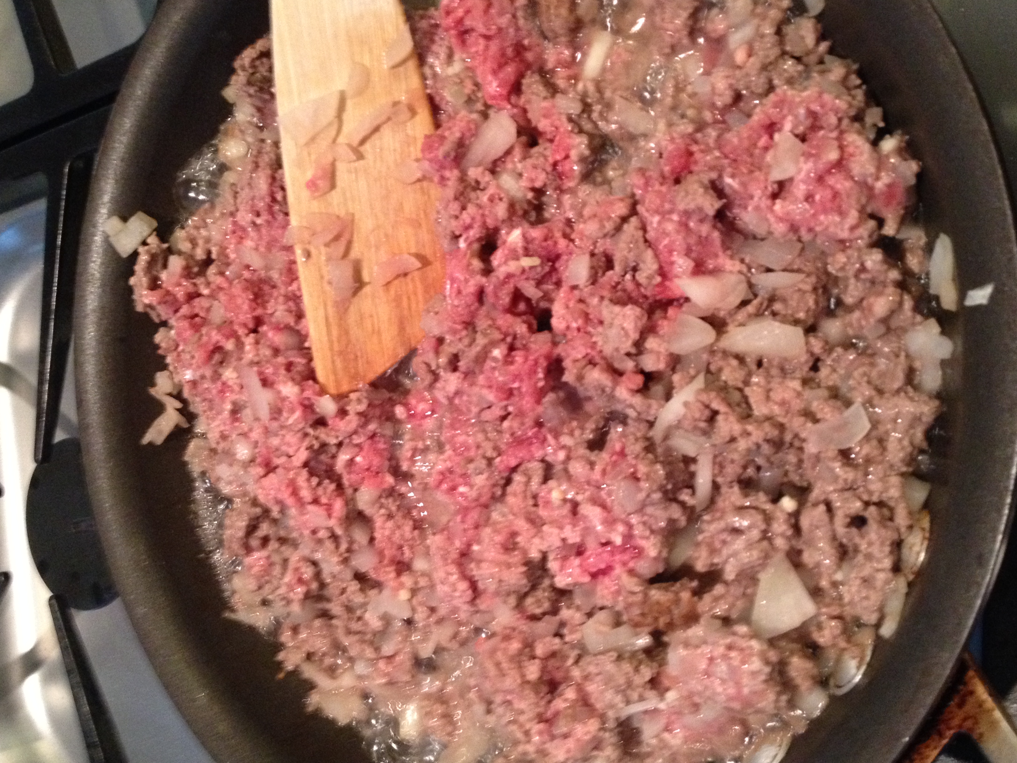 Stir onions and ground beef together and cook till no longer pink.