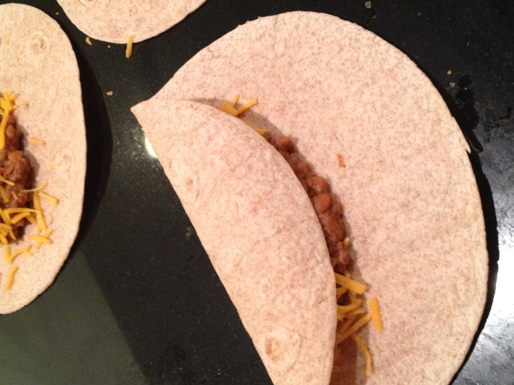 Step one for rolling them up:  Roll over one side of the tortilla.   With this recipe I like to roll them into little pouches.  