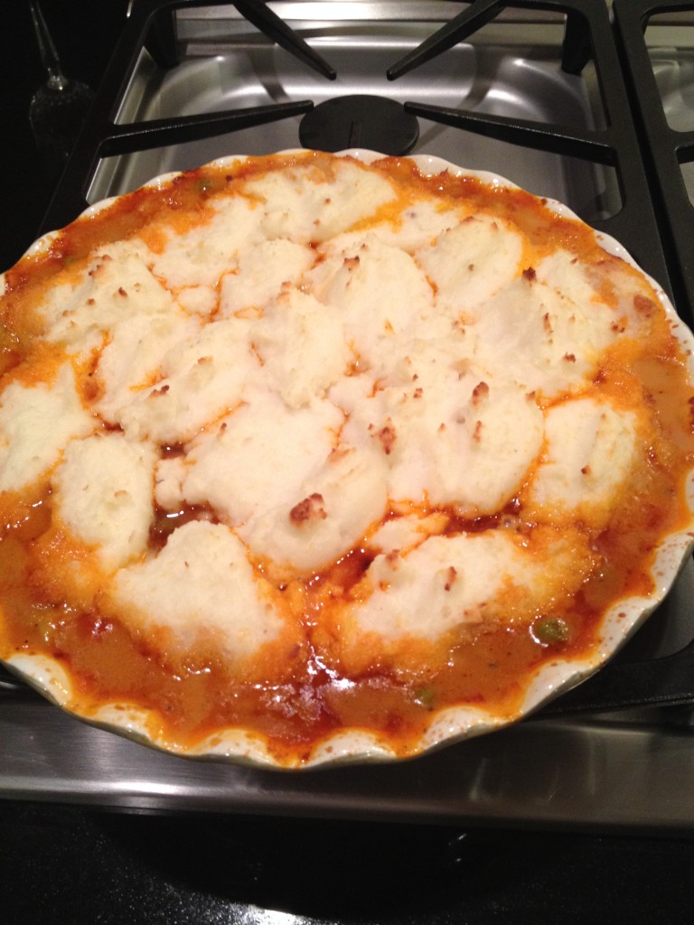 Meat Mixture in pie pan and topped with potatoes.