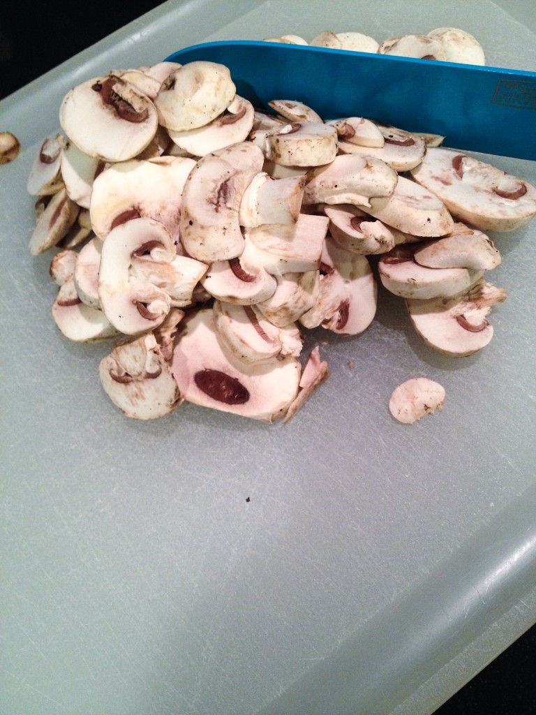 Mushrooms ready for chopping.  Tidbit Tip - If your chopping sheet does not have a slide proof bottom wet a paper towel and place under it.  This will keep it from sliding.